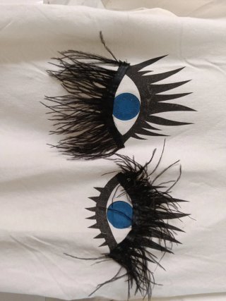 Camiseta blanca con ojos y plumas