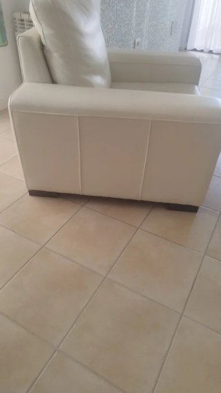 elegante Sillón de piel beige.con patas de madera