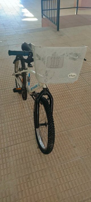 Bicicleta infantil B'TWIN blanca con cesta.
