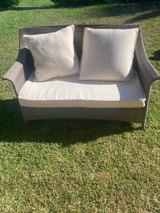 Sofá 2 plazas y sillón ratán marrón con cojines.