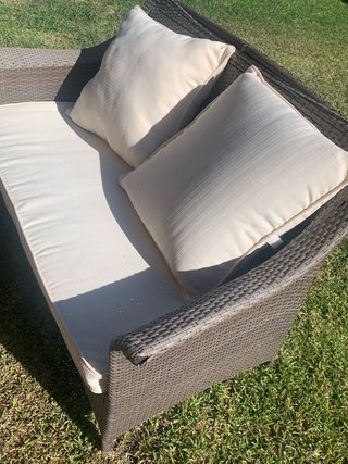 Sofá 2 plazas y sillón ratán marrón con cojines.