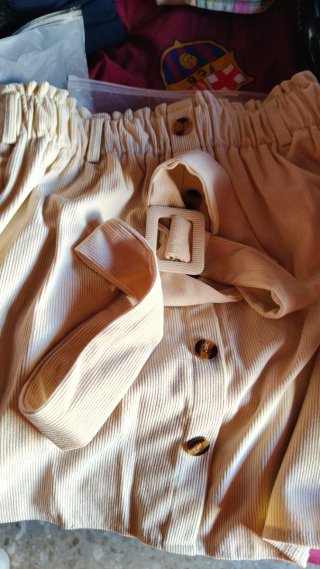 Falda larga beige con botones. Y con cinturón.