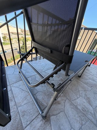Tumbona reclinable y plegable con toldo regulable.