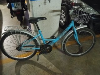 Bicicleta azul con cesta y portabultos