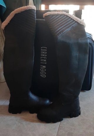 Botas altas negras por encima de la rodilla