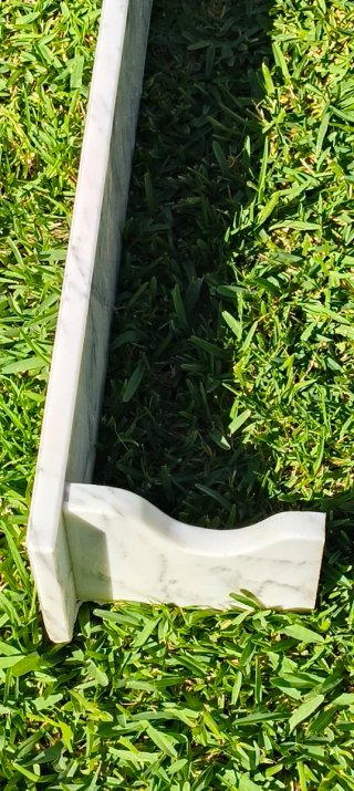 Repisa de mármol con vetas blancas y grises.