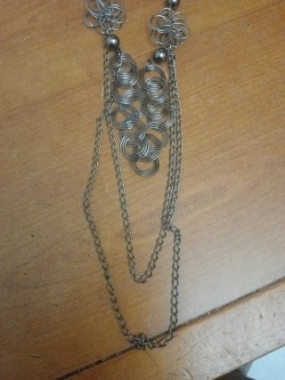 Collar plateado con diseño de flores y círculos
