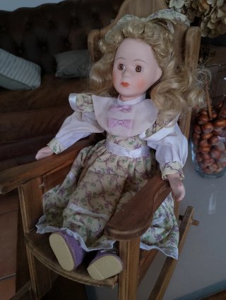 Muñeca de porcelana en mecedora