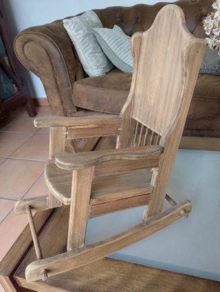Muñeca de porcelana en mecedora