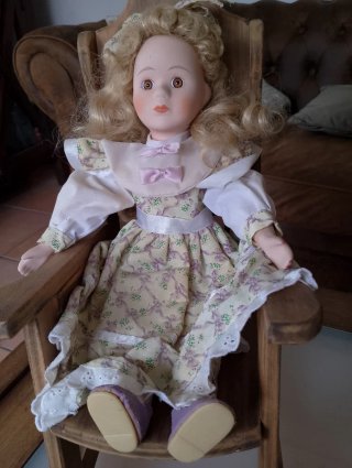 Muñeca de porcelana en mecedora