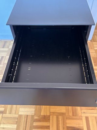 Cajón de escritorio metálico negro.