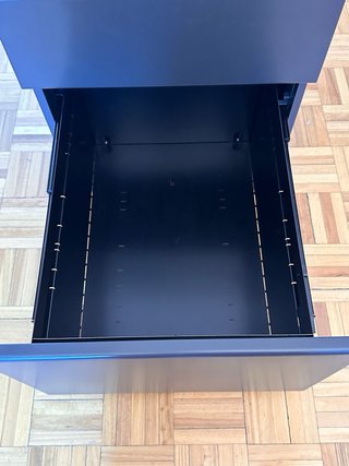 Cajón de escritorio metálico negro.