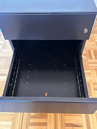 Cajón de escritorio metálico negro.