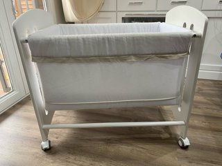 Minicuna blanca con ruedas y jirafa