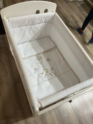 Minicuna blanca con ruedas y jirafa