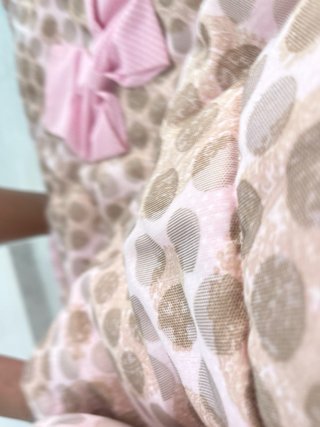 Funda carricoche rosa con volantes y lunares.