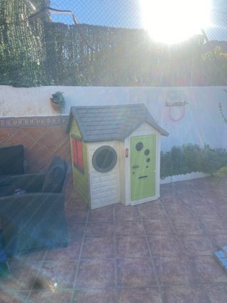 Casita de juguete verde con puerta roja