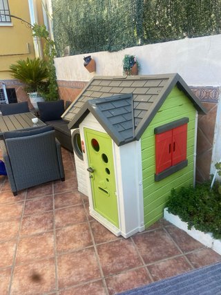 Casita de juguete verde con puerta roja
