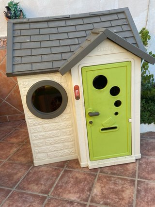 Casita de juguete verde con puerta roja