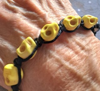 Bracciale con teschi gialli e perle nere in ematit