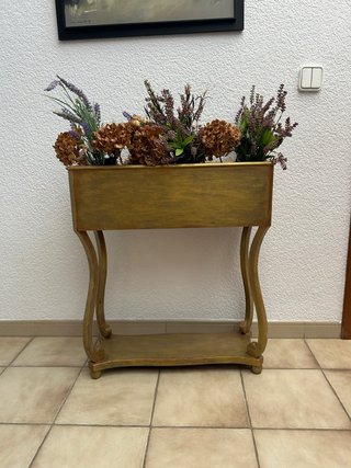 Mueble de entrada dorado con plantas