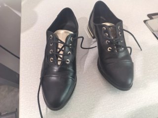 Zapatos negros con cordones y detalles dorados