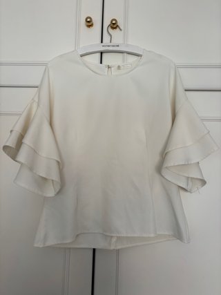 Blusa blanca entallada con mangas de volantes