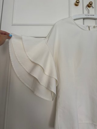 Blusa blanca entallada con mangas de volantes