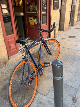 Bicicleta de carretera azul con ruedas naranjas