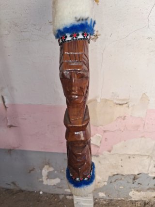 Bastón tallado con flechas y caras indias