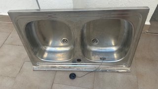 Fregadero doble de metal recién quitado