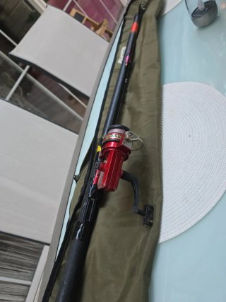 Caña de pescar con carrete rojo y funda.