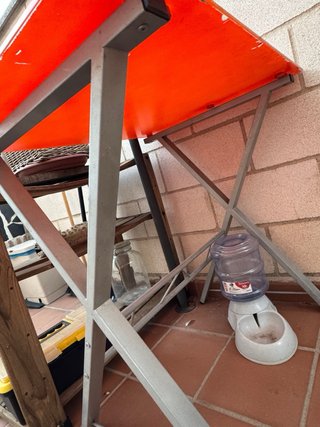Mesa cristal naranja con patas metálicas