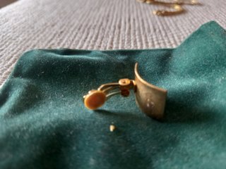 Set di gioielli dorati con ciondolo e orecchini con pietre verdi