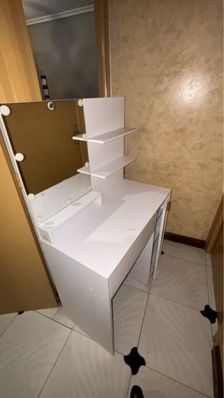 Tocador blanco con espejo y estantes.