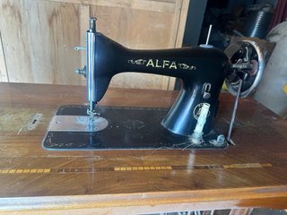 Máquina de coser Alfa antigua con mueble