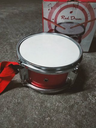 Tambor rojo con caja y baquetas