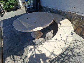 Mesa de piedra redonda con banco curvo