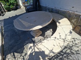 Mesa de piedra redonda con banco curvo