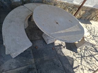 Mesa de piedra redonda con banco curvo