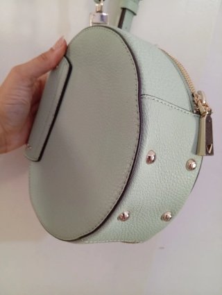 Bolso redondo verde con tachuelas