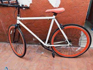 Bicicleta blanca con ruedas naranjas