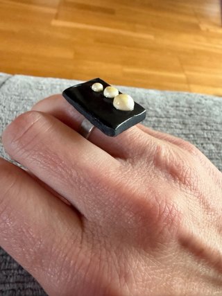 Anillo negro con detalles beige y blanco