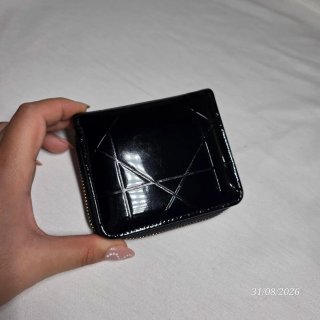 Cartera negra brillante con charm.