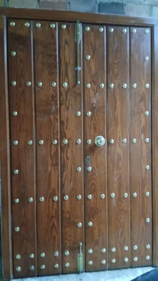 Puerta de madera entrada con clavos de laton