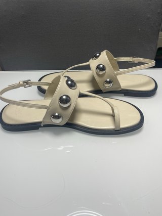 Sandalias planas beige con detalle plateado