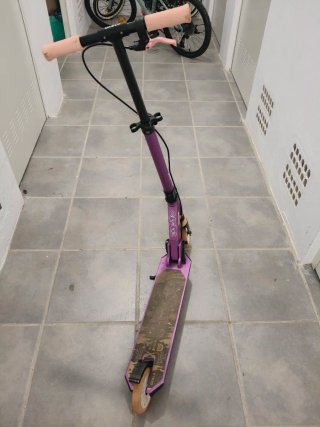 Patinete morado con ruedas naranjas