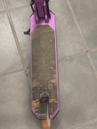 Patinete morado con ruedas naranjas