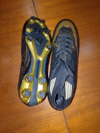 Zapatos de fútbol negros y dorados