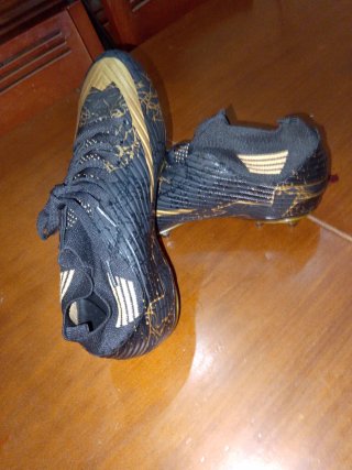 Zapatos de fútbol negros y dorados